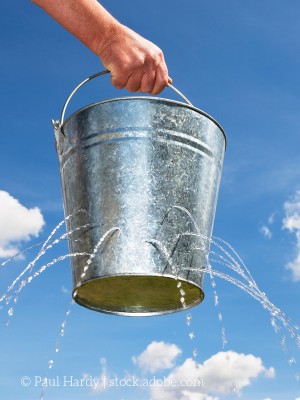 Eimer mit kleinen Löchern, aus denen Wasser strömt.