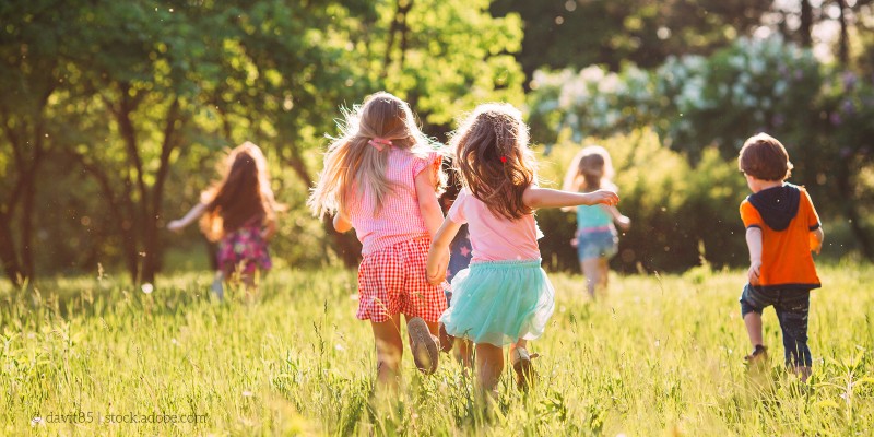 Kinder spielen auf einer Wiese