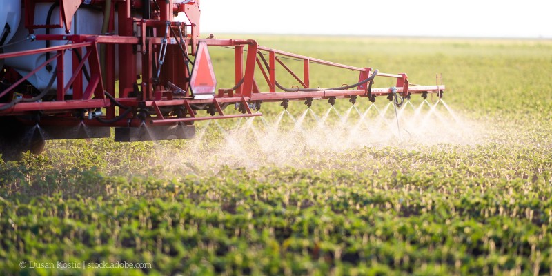 Traktor versprüht Pestizide auf einem Acker